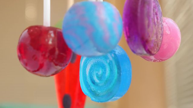 colorful lollipops hang in the air. 4k slow motion