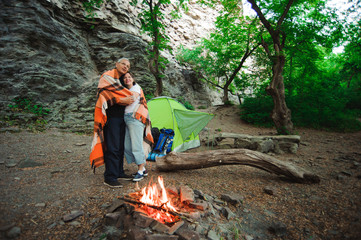 Tent camping couple romantic standing by bonfire night countryside