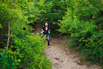 Traveler man walking with backpack in rocky mountains. Travel concept.