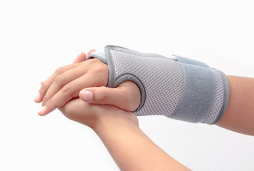 Woman's hand with wrist orthosis on white background