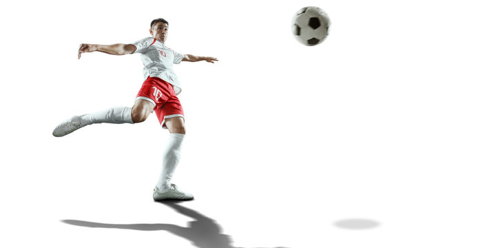 Soccer player performs an action play and beats the ball. Isolated football player in unbranded sport uniform on a white background.