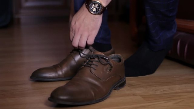 A man is putting on shoes