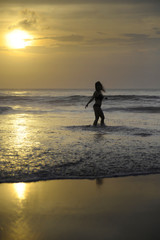 Fototapeta na wymiar young woman on sea landscape sunset horizon with amazing sun and dramatic orange sky