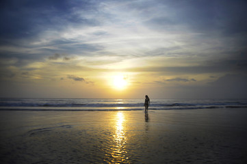 Fototapeta na wymiar young woman on sea landscape sunset horizon with amazing sun and dramatic orange sky