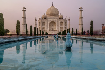 Obraz premium The famous Taj Mahal, Agra, India, is reflected in the water of the gardens' pools at dusk