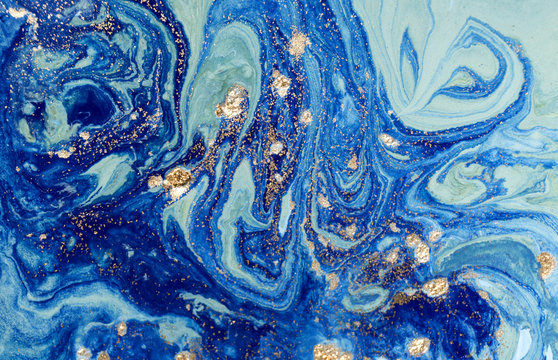 Marbled blue abstract background with golden sequins. Liquid marble ink pattern. © anya babii