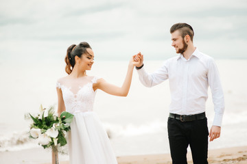 young couple groom with the bride on a sandy beach