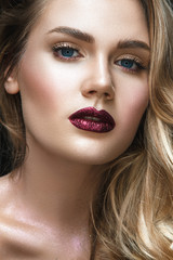 Beautiful woman portrait on black background with shiny make up and shiny powder on skin.