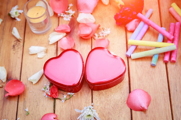 Red heart box with flower petals decorative on wooden table. background for valentines day concept