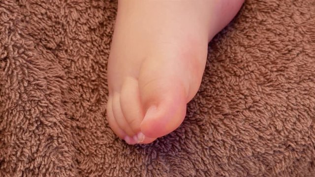 Baby legs on a brown blanket. Family concept. Beautiful conceptual video of Maternity. 4k video