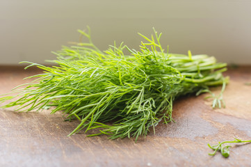 green dill on cutting desk, soft focus