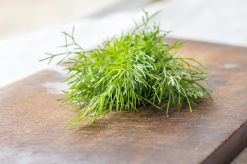green dill on cutting desk, soft focus