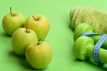 Barbells by juicy green apples. Diet and sport regime concept
