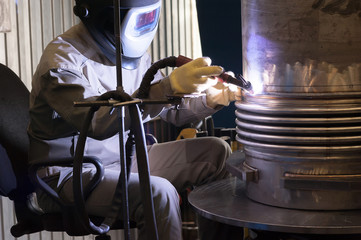 Welder with protective mask welding metal and sparks