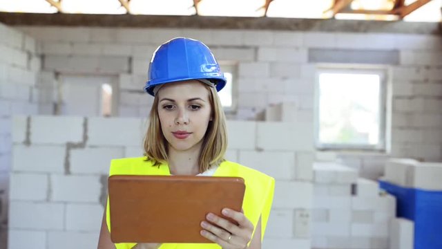 Young woman with tablet at the construction site.