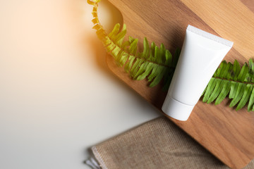 Cosmetic bottle containers with green herbal leaves, Blank label for branding mock-up, Natural beauty product concept