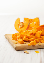 Pumpkin cut into pieces on the kitchen Board on a white