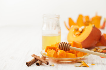 Drizzled with honey pumpkin cut into pieces in the dish, honey and cinnamon