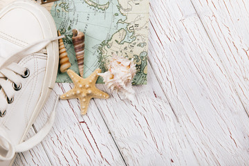 Seastars lie behind white keds on travel map