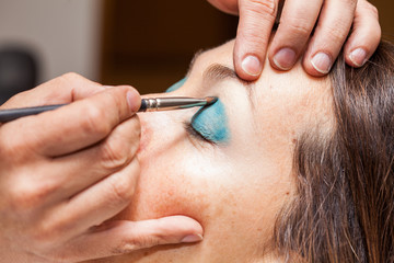 Make up artist applying eyeshadow to a woman