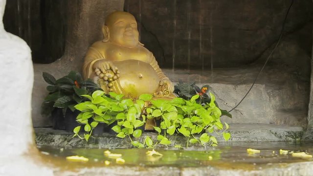 Golden Buddha statue in little pond with water stream. Golden mount (Wat Saket) Bangkok Thailand.