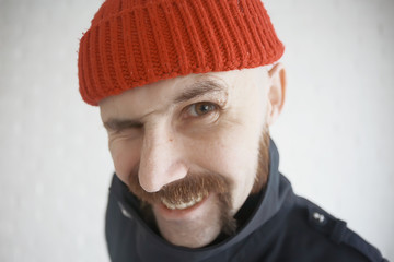 guy with a mustache in a red knitted hat