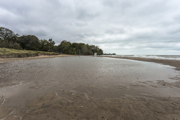 Looking down a reflective pool of water on the beach