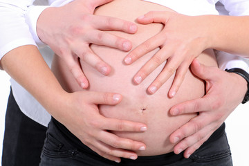 Babybauch mit vielen Händen beschützend Nahaufnahme