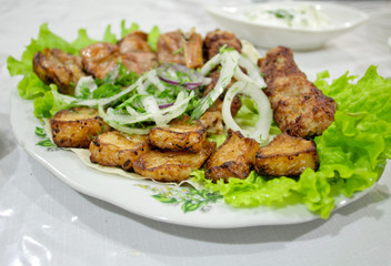 Barbecue beef with onion and salad on the plate. Oriental cuisine in Azerbaijan