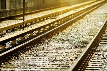 Naklejka premium Railroad tracks in perspective with sunlight against