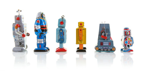 SWINDON, UK - OCTOBER 1, 2017: Row of old clockwork tin robots in a line on a white background