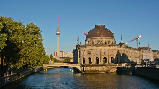 Boat cruises in front of the Bode Museum at sunset in Berlin.