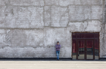 abstract cement dirty wall, old concrete wall with a door, a man near the wall