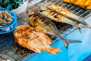 fresh fish cooked on the grill, street food in Thailand