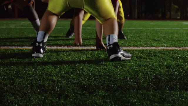 Football players lining up for a play before the quarterback snaps the ball