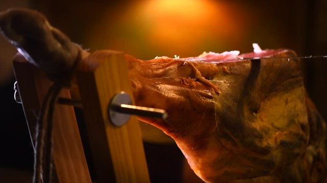 Jamon serrano. Slicing traditional spanish ham closeup. 4K UHD video 3840x2160  