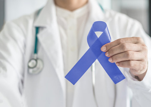 Periwinkle blue ribbon awareness with color bow on medical doctor's hand for stomach and small intestine cancer, esophageal cancer, eating disorder, Irritable Bowel Syndrome (IBS) awareness