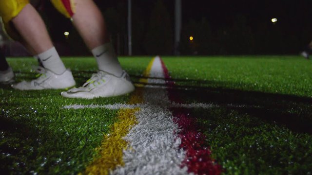 Close up of a football, as players get set at the line of scrimmage