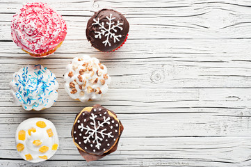 variety of cupcakes on white wooden background top view