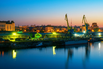 Fototapeta premium urban night view with cranes at river