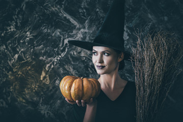 Halloween Witch holding a pumpkin and a broom. 