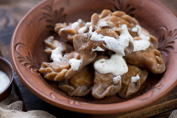 Closeup of russian boiled vareniki or rye dumplings stuffed with sauerkraut, studio shot, selective focus