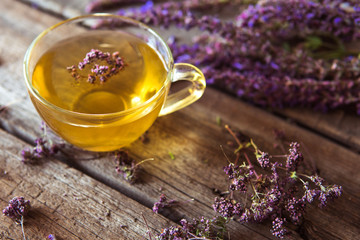 Green tea with herbals. Tea with oregano on the wooden background