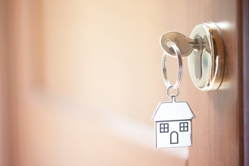 A key in a lock with house shape on it