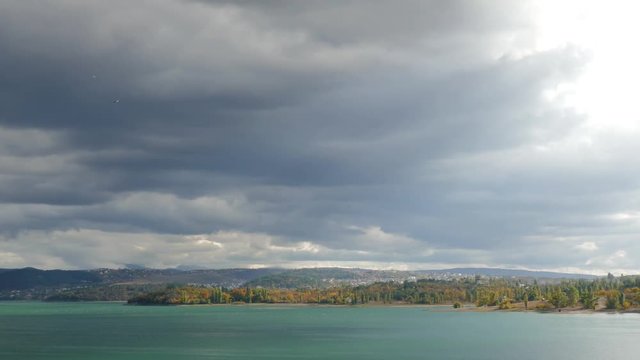 Autumn landscape with mountain lake / Lake and forested hills on background of sky with stormy clouds