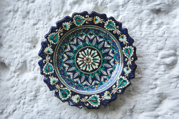 Ethnic Uzbek ceramic tableware. Decorative ceramic plate with traditional uzbekistan ornament.