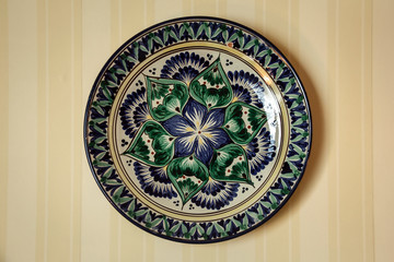 Ethnic Uzbek ceramic tableware. Decorative ceramic plate with traditional uzbekistan ornament.