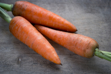 Young fresh carrots on wooden background. Organic natural food