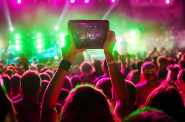 Video recording of the concert on the phone a smartphone. Reggae colors. Blue conceptual background...