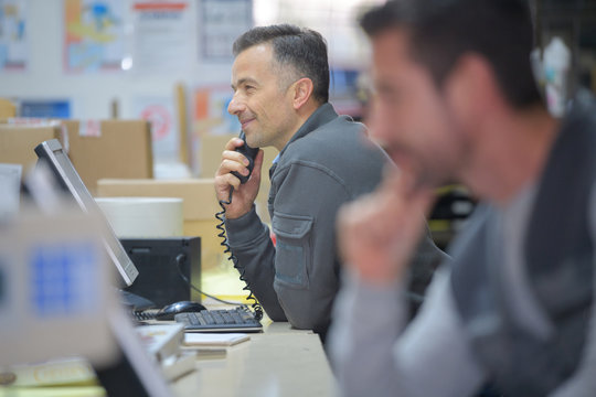 Warehouse Manager On The Phone In A Warehouse